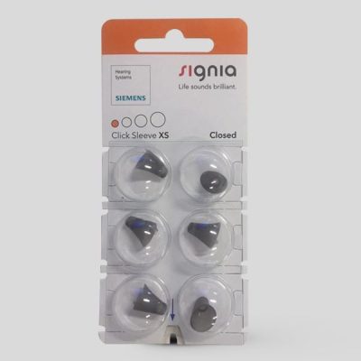 Six Signia Click Sleeve (Closed) XS ear tips for hearing aids are shown in a blister pack, with branding and product details visible on the packaging.