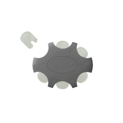 A black and gray gear-shaped object with six rounded protrusions and a central oval resembles the Bernafon ProWax. A small, translucent, rectangular piece with a notch is seen near the top left of this ProWax filter.