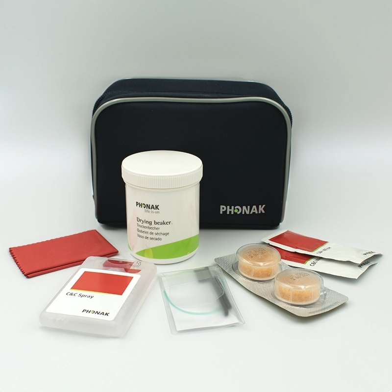 The C&C Kit 2 ITE & BTE includes a black zippered pouch, drying beaker, cleaning cloth, two wipes, spray, drying capsules, and a cleaning tool—all arranged on a white surface.