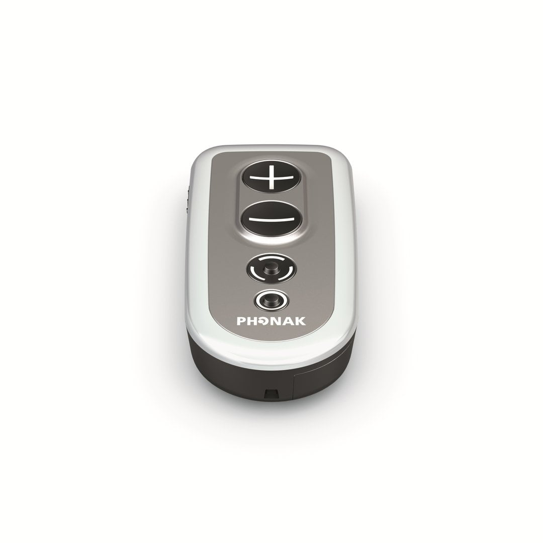 The Phonak PilotOne II is a compact, oval remote with two large plus and minus buttons and a smaller circular button below them, shown against a white background.