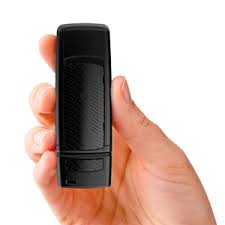 A hand holds the Starkey SurfLink Mini Mobile, a compact black device, vertically against a plain white background.